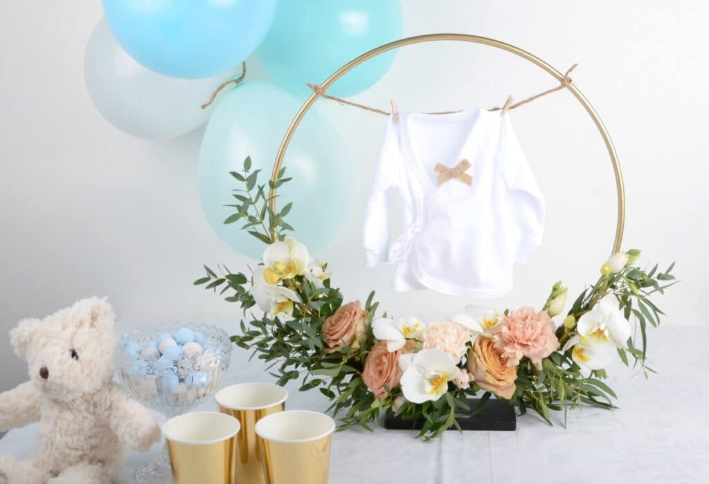 Kukilla ja suloisella vauvanvaatteella koristeltu pystykranssi on Baby shower -juhlien ihastelun aihe. 